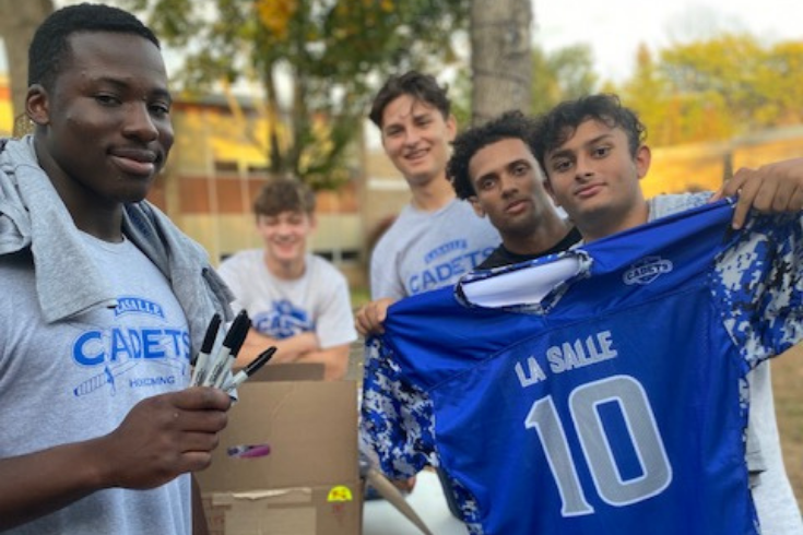 Student holding up a football jersey